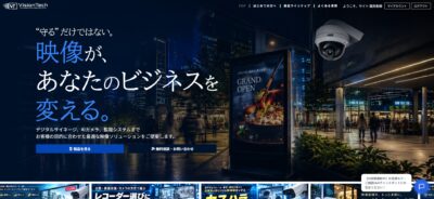 夜の商業施設に設置された監視カメラと広告画面